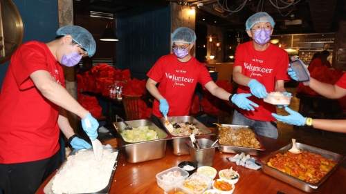 另一批义工负责装餸舀汤舀饭。