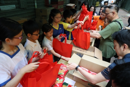 建华集团5号佛诞当日向银杏馆长沙湾分店捐赠食材，由星岛集团我要赞佢大使、校长及家长二十多人到场组装成福袋送赠长者。