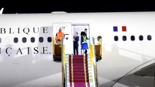 机舱门一开，马克龙在镜头下被妻子狠推脸。 路透社