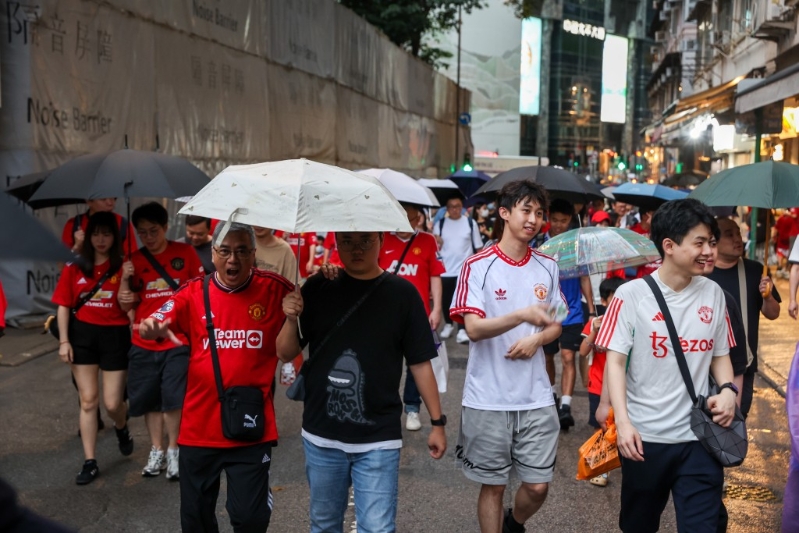 球迷冒雨入场。 何家豪摄