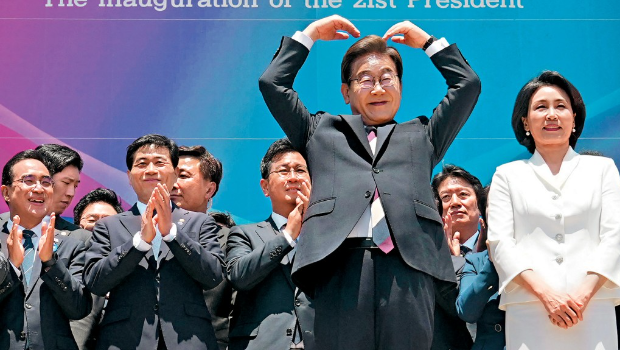韩国新总统李在明偕夫人出席就职礼后,在国会外做出心形手势。 韩国新总统李在明偕夫人出席就职礼后,在国会外做出心形手势。