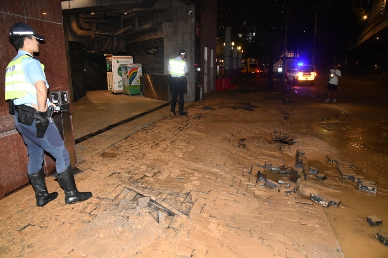 大量黄泥水冲破路砖，夹杂沙石涌出路面。