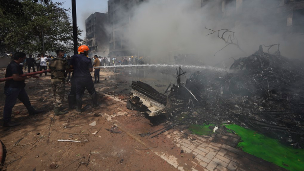 印度航空一架波音787-8型客机12日起飞后不久发生空难，救难人员赶赴现场灭火，地上满是机骸，惨不忍睹。