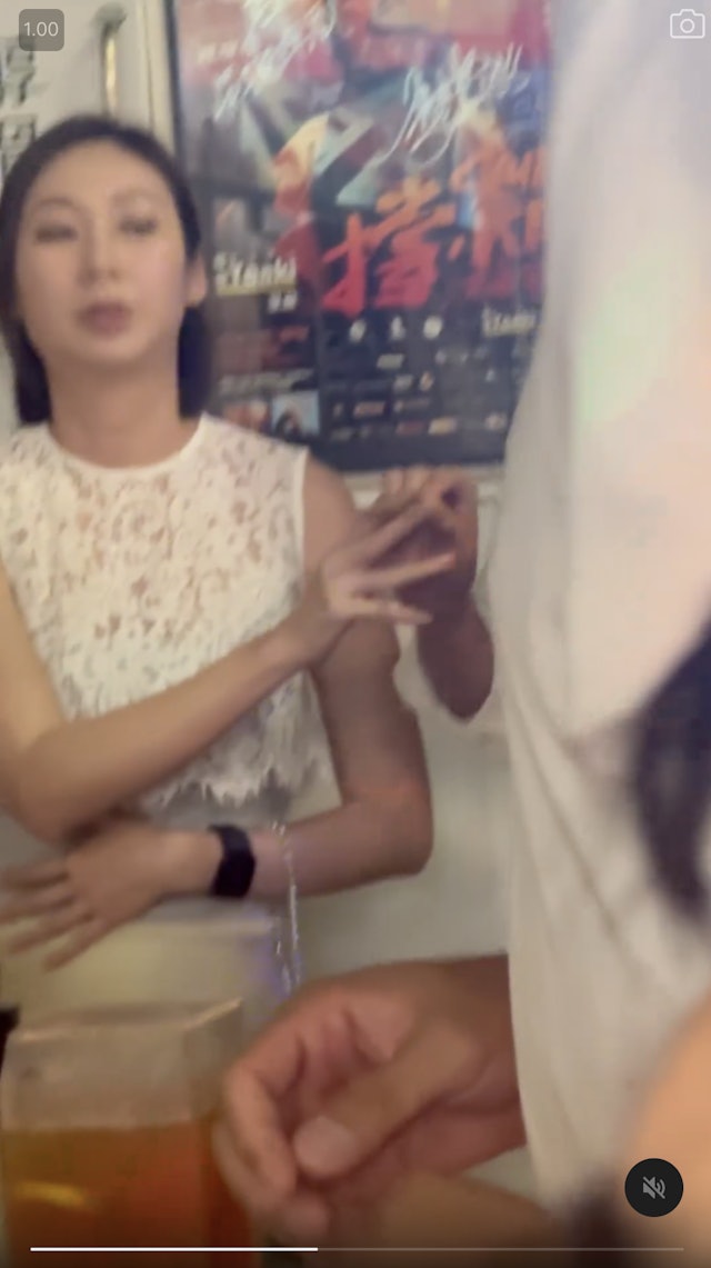 庄思敏将烟传予友人。 庄思敏将烟传予友人。