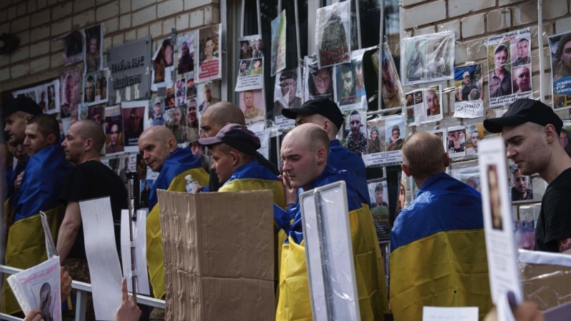 获释回家的乌克兰士兵仔细观看失踪人士兵照片及家属留言。 美联社.jpeg