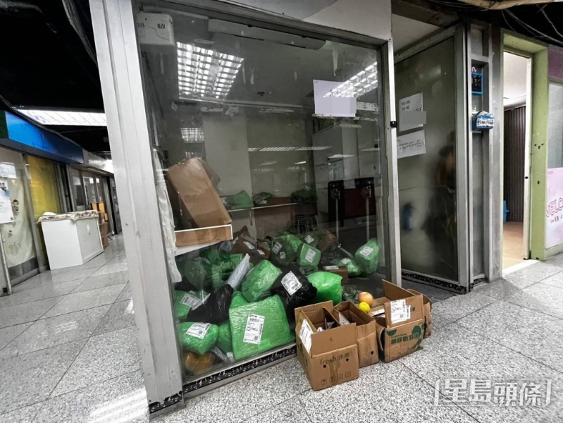 同一商场内，附近一间空置舖位有大量未拆开的包裹散落一地。