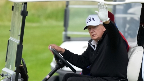 美国总统特朗普27日在苏格兰登拜里（Turnberry）开高球车，向在场媒体记者挥手致意。美联社