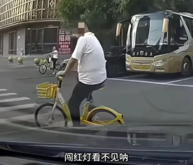 单车疑冲红灯险撞私家车。