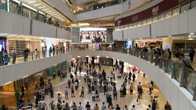 观塘aPM商场直播阅兵仪式，市民驻足观看，赞军人英姿飒飒