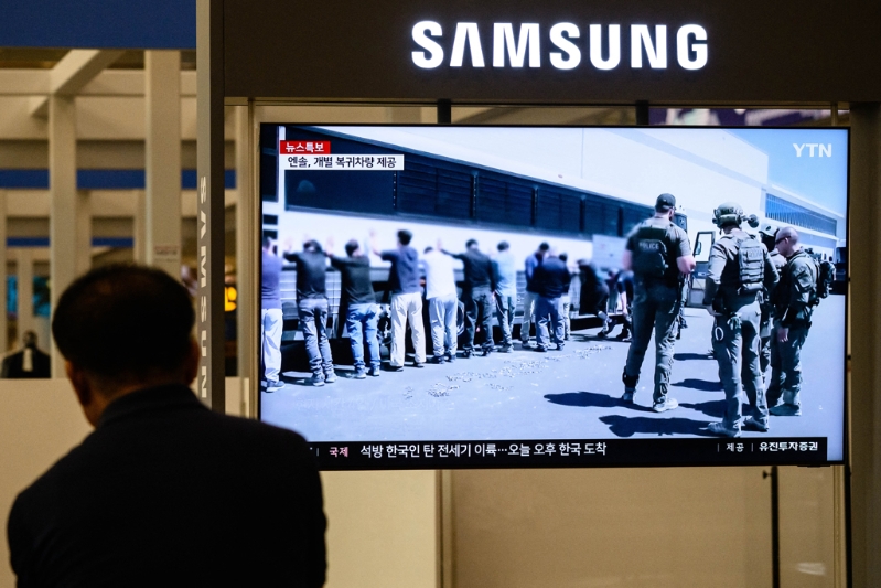 韩国被拘留工人被迫站在巴士前的档案画面。