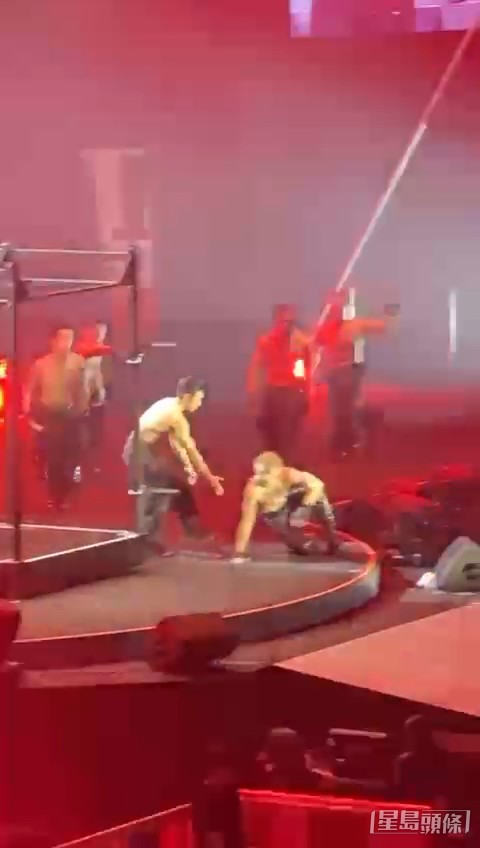 关智斌在舞者协助下试图站起来。 关智斌在舞者协助下试图站起来。