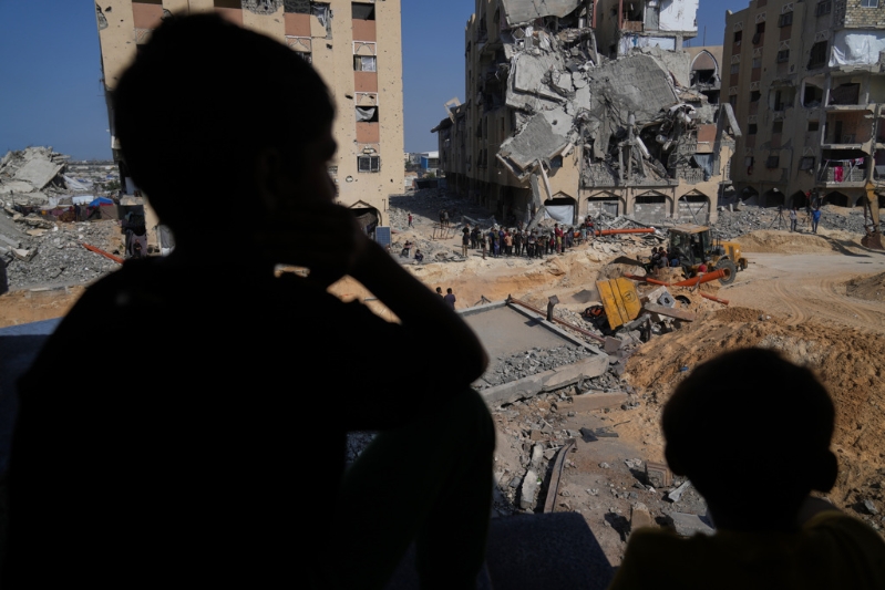 2025年10月17日,在加沙南部城市汗尤尼斯的哈玛德住宅区,民众看着哈马斯武装成员活动。 2025年10月17日,在加沙南部城市汗尤尼斯的哈玛德住宅区,民众看着哈马斯武装成员活动。