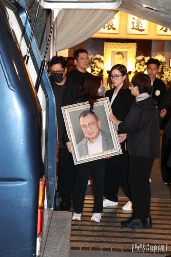 许惠菁捧着遗照上灵车随行。