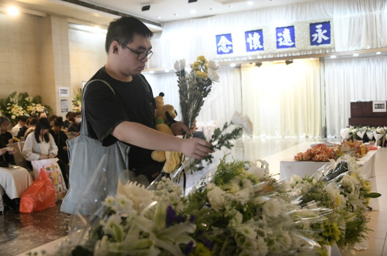 巿民向死难者献花。