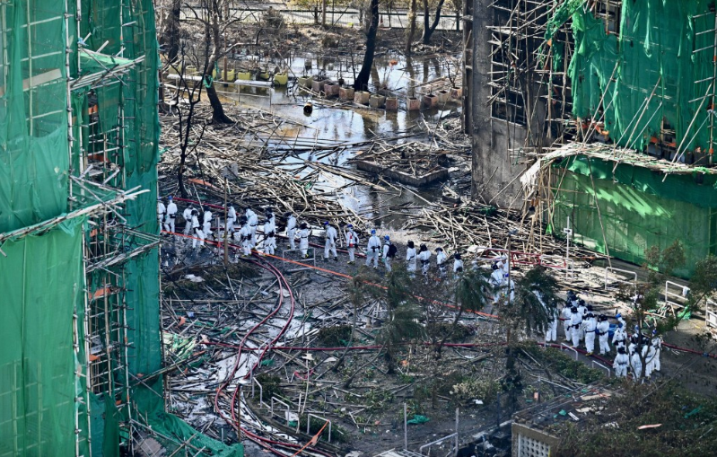 火场一片颓垣败瓦,警员入内调查。 火场一片颓垣败瓦,警员入内调查。
