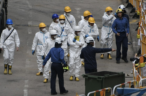 一众人士身穿全套白色保护衣。