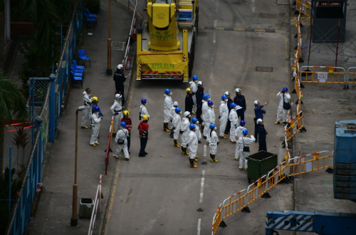 委员会成员连同工作人员，身穿保护衣到灾场巡视。