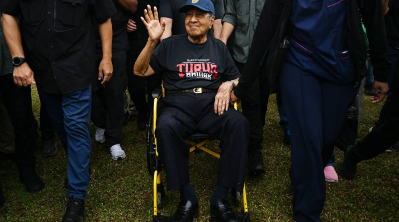 马来西亚百岁前首相马哈蒂尔家中摔倒入院。图为他去年坐轮椅出席群众活动