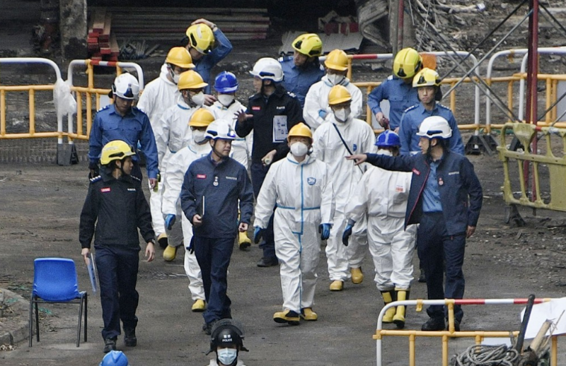 独立委员会成员连同工作人员，身穿保护衣到灾场巡视。