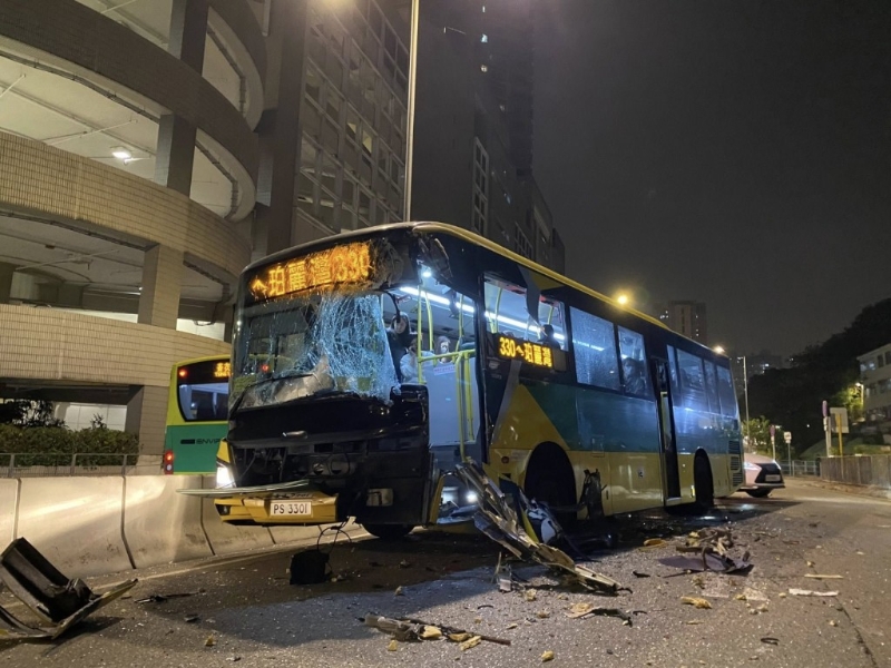 居民巴士挡风玻璃碎裂，零件散落一地。