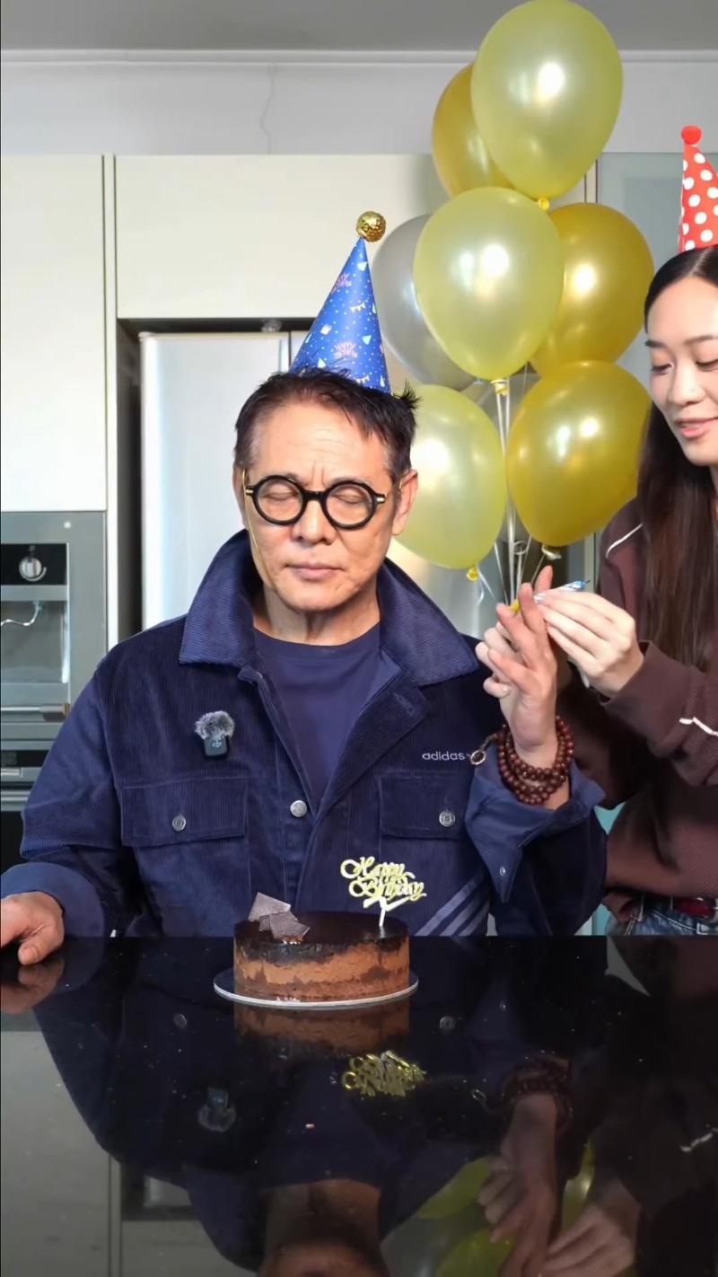 Jada将蜡烛插在父亲李连杰的手指之间。